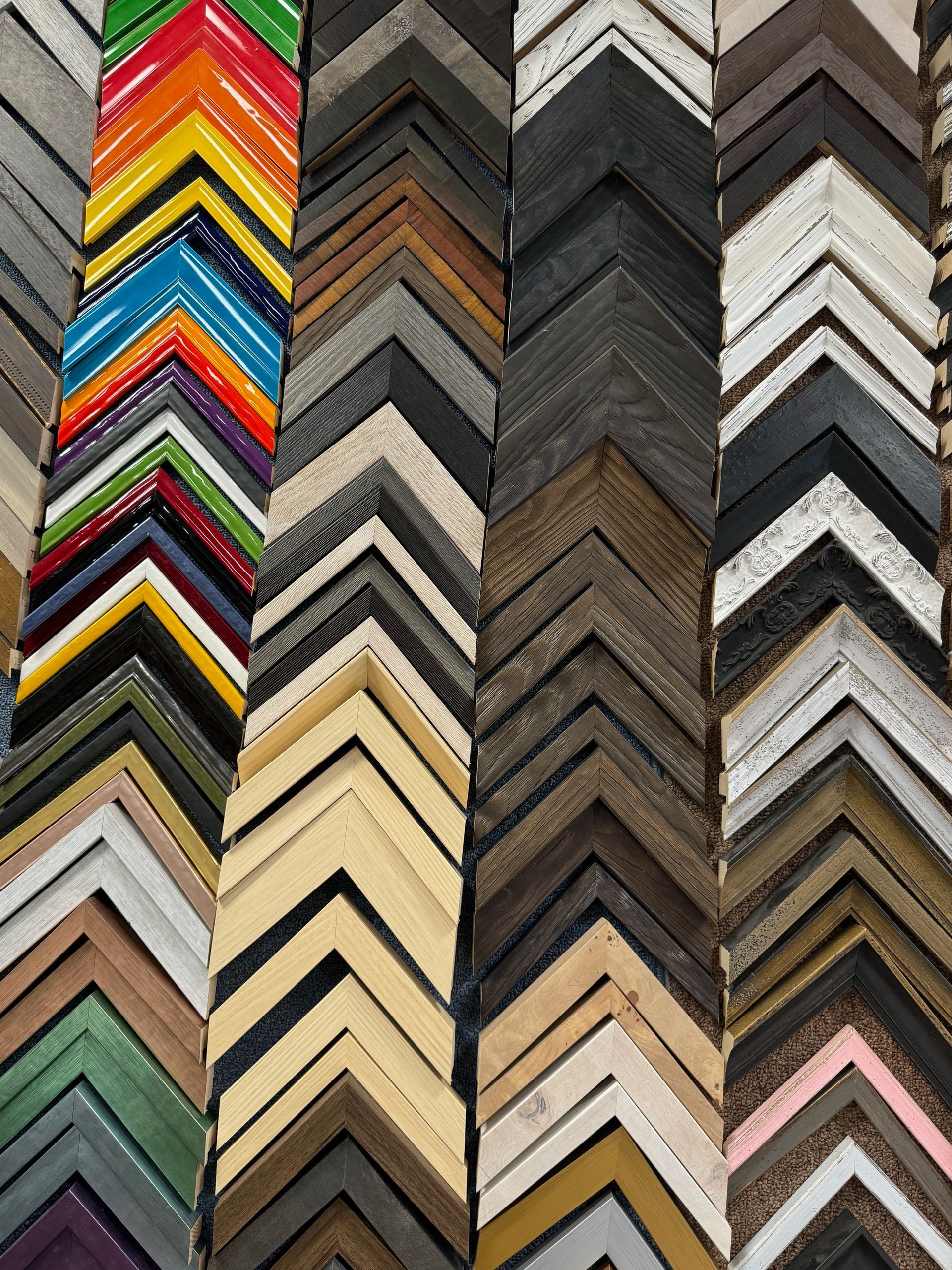 A bunch of different colored picture frames are stacked on top of each other.