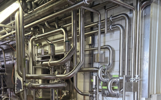 Sanitary stainless process piping installation completed by United Process Piping for a manufacturing facility.