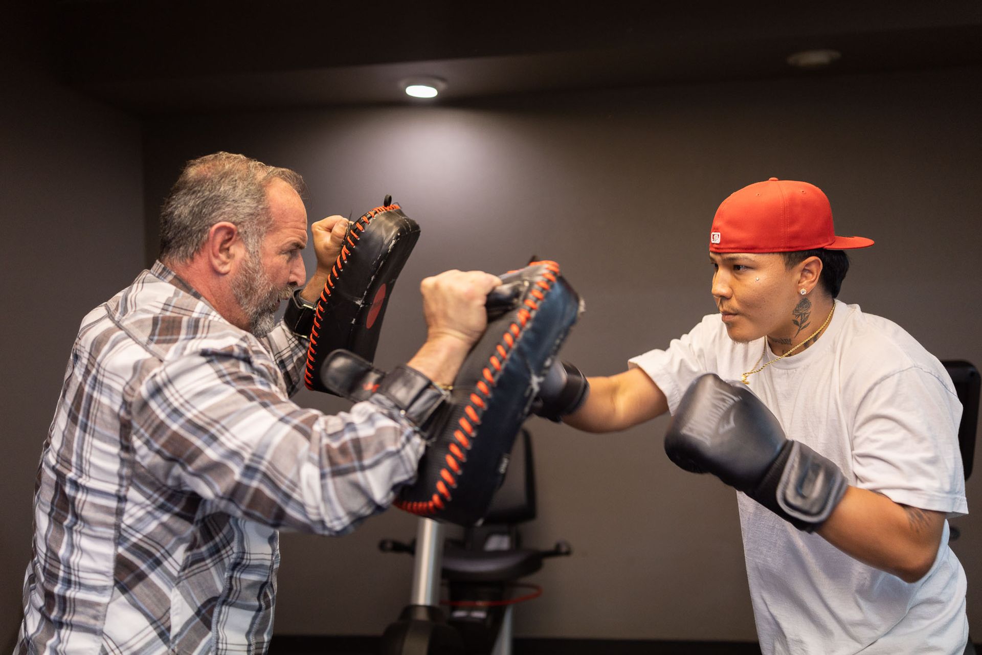 Trainer assisting a person using a cable machine in a gym