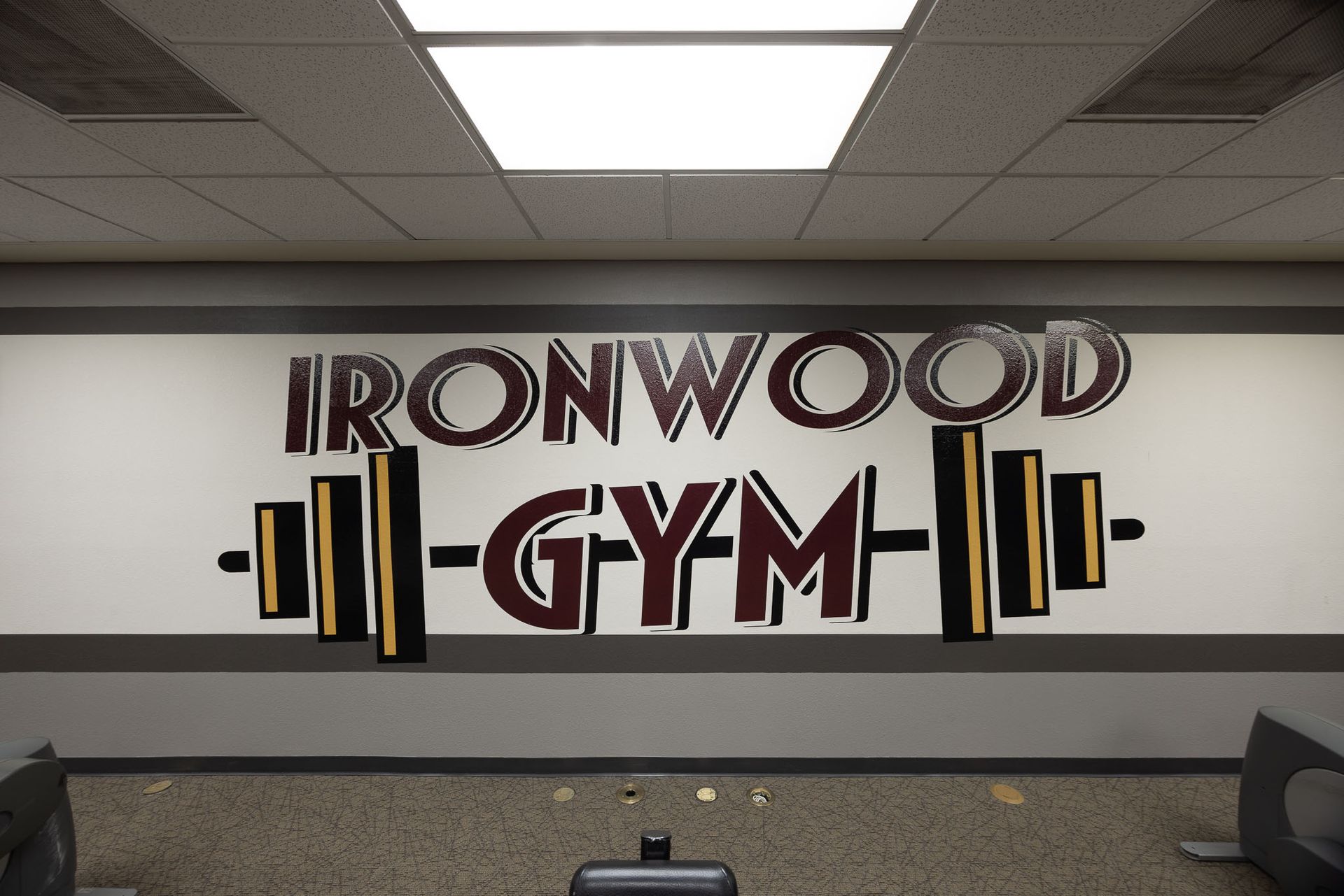 Ironwood Gym wall sign in black and gold on a white wall