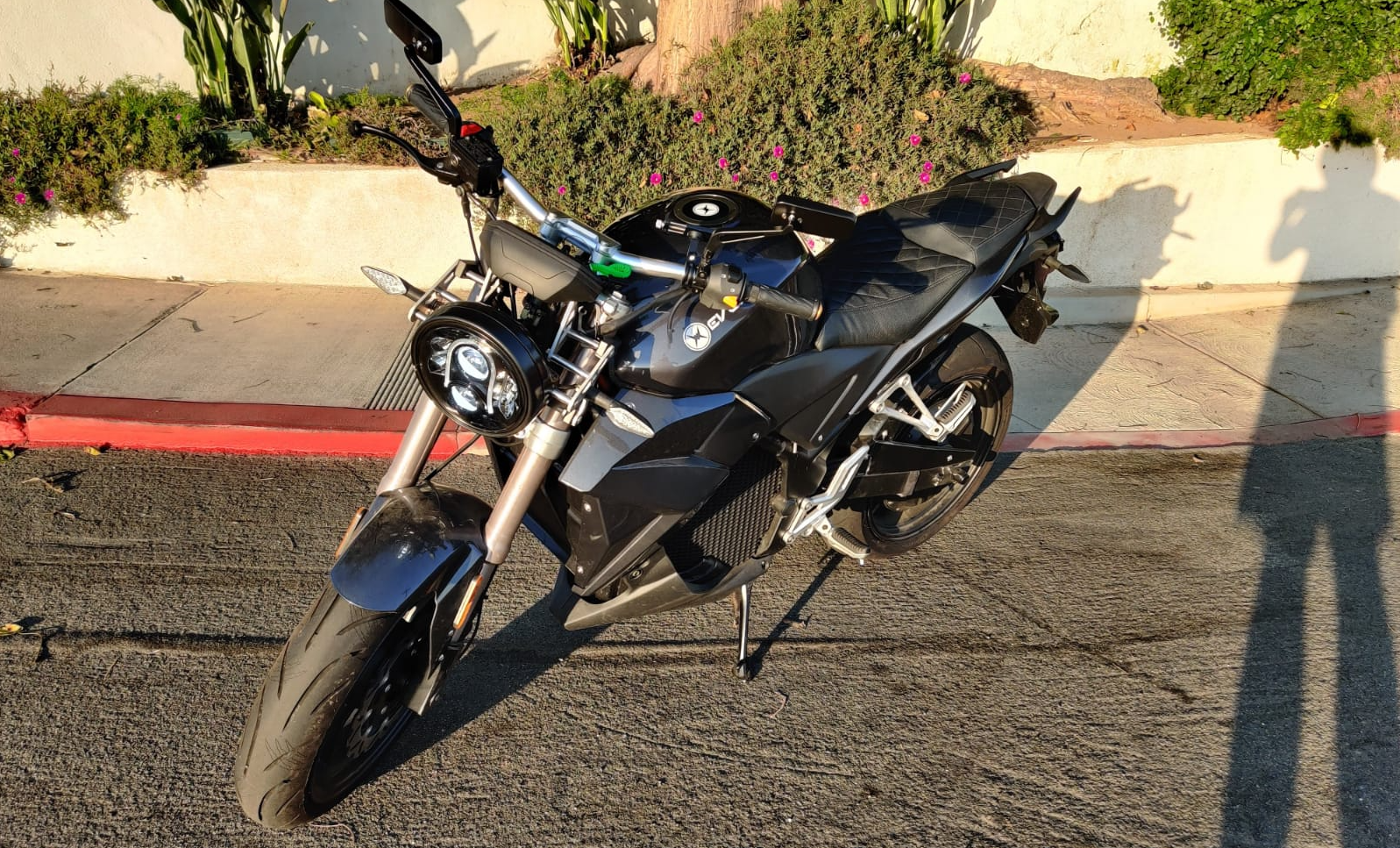 A black electric motorcycle is parked on the side of the road in Los Angeles. Urban Classic 2020