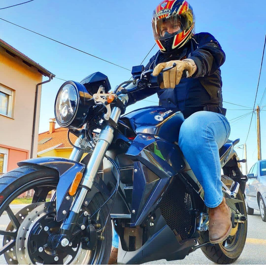 A man wearing a helmet is riding a blue electric motorcycle. 2019 Urban Classic Estonia