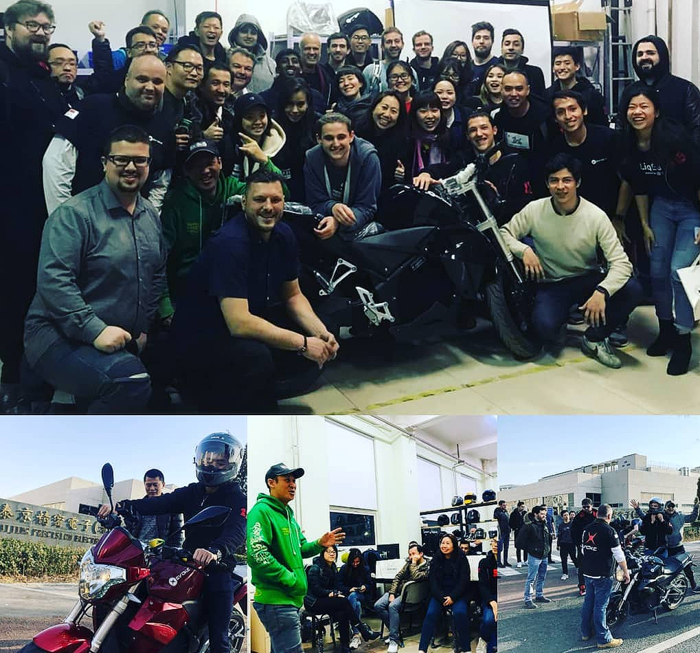A group of people posing for a picture with Evoke Motorcycles electric motorcycles