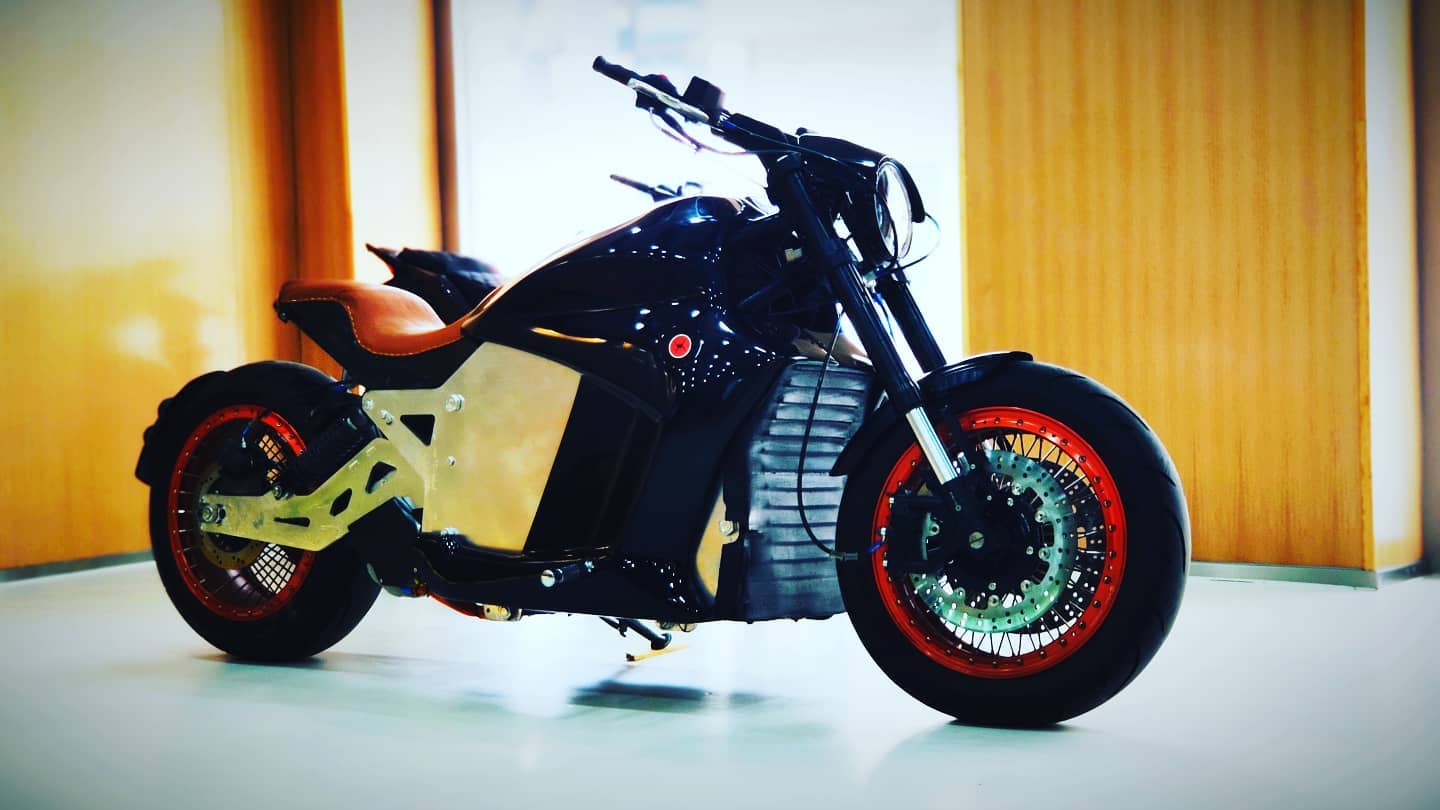 A black 6061-GT electric motorcycle with red wheels is parked in a showroom in Vegas, USA.
