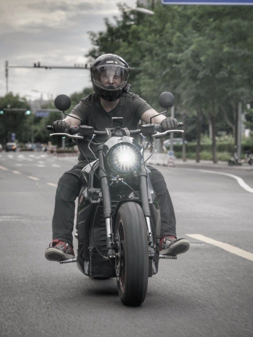 Nathan Siy is riding a 6061-GT electric motorcycle down a city street in Vancouver, Canada 2020.