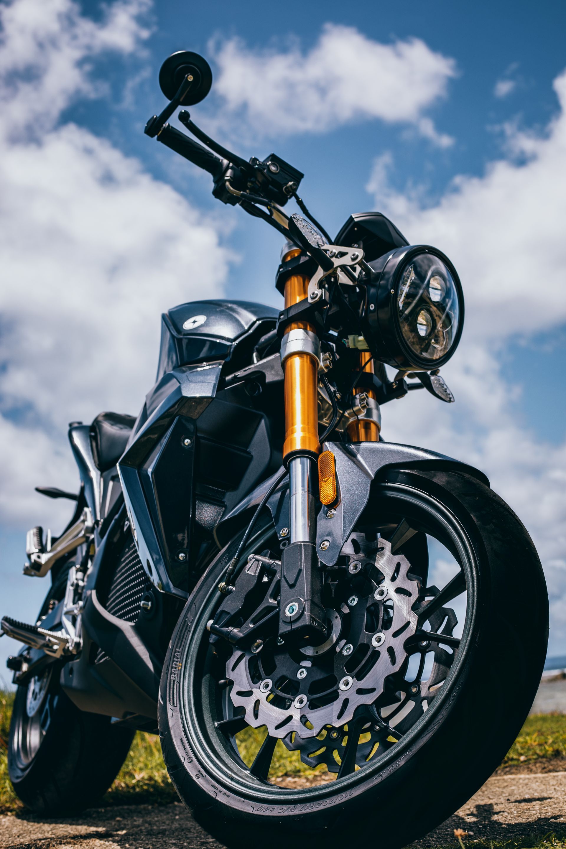 A close-up of an electric motorcycle parked on a dirt road. Urban Classic 2021
