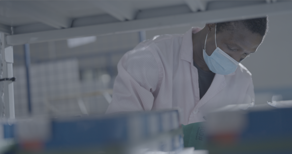 A man wearing a mask and a lab coat is working in a lab at Evoke Motorcycles R&D in Beijing at Foxconn Plant.