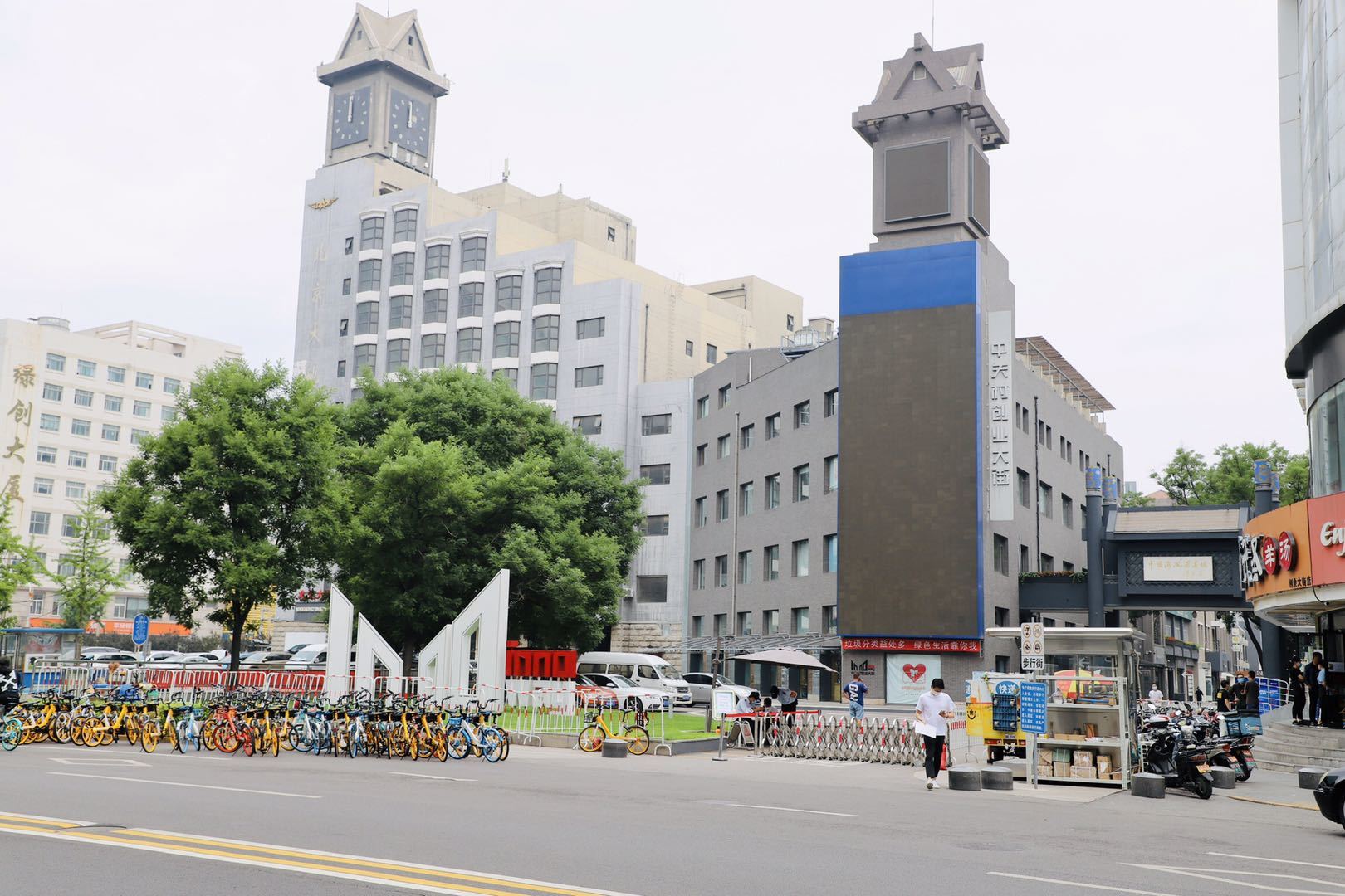 A city street with a clock tower in the middle of it.