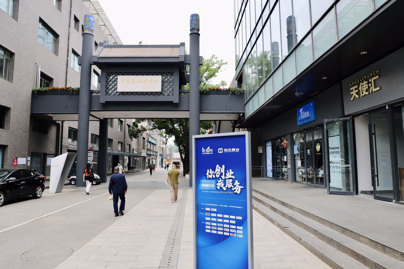 People walking down a sidewalk in front of a building