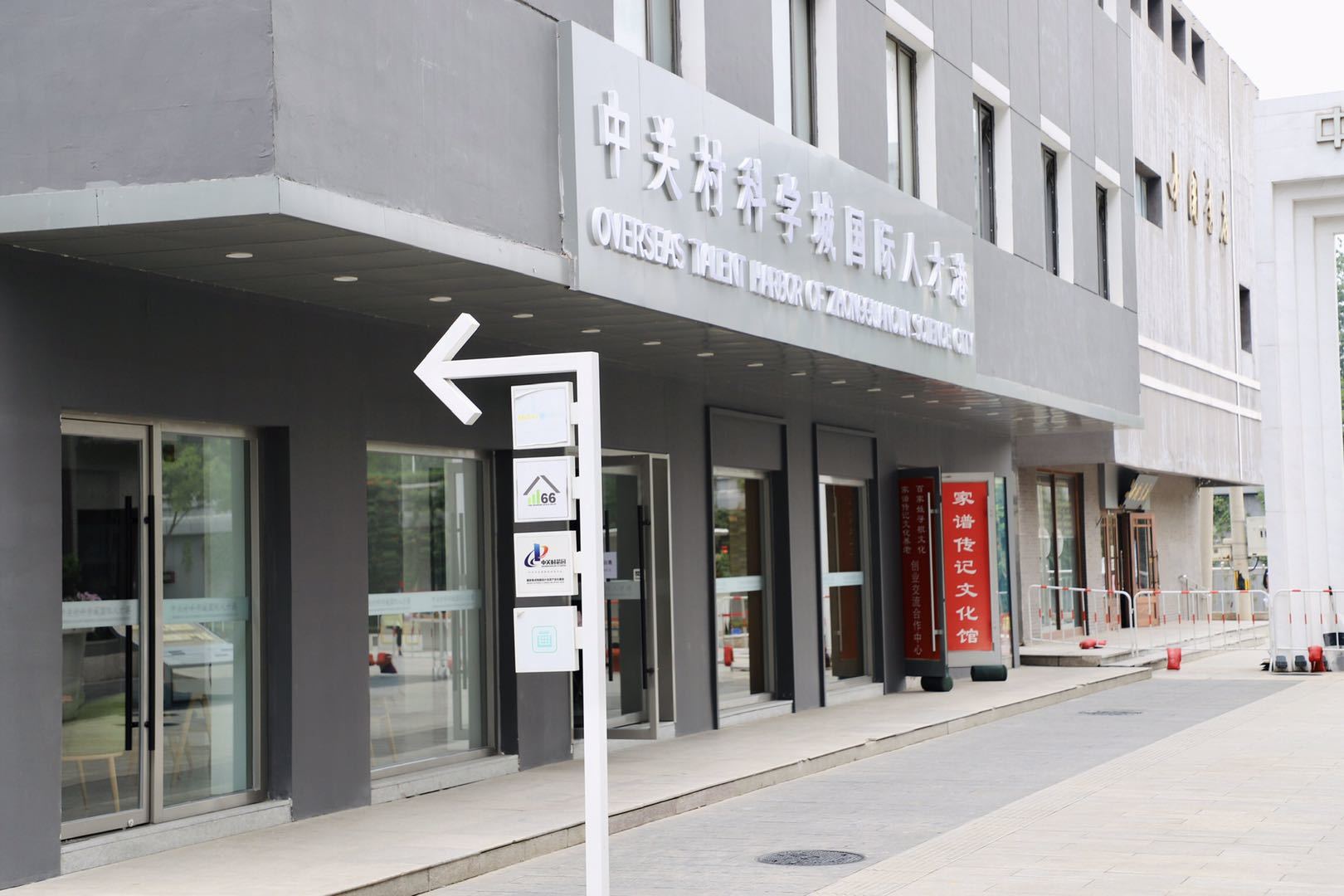 A building with chinese writing on it and a sign pointing to the left