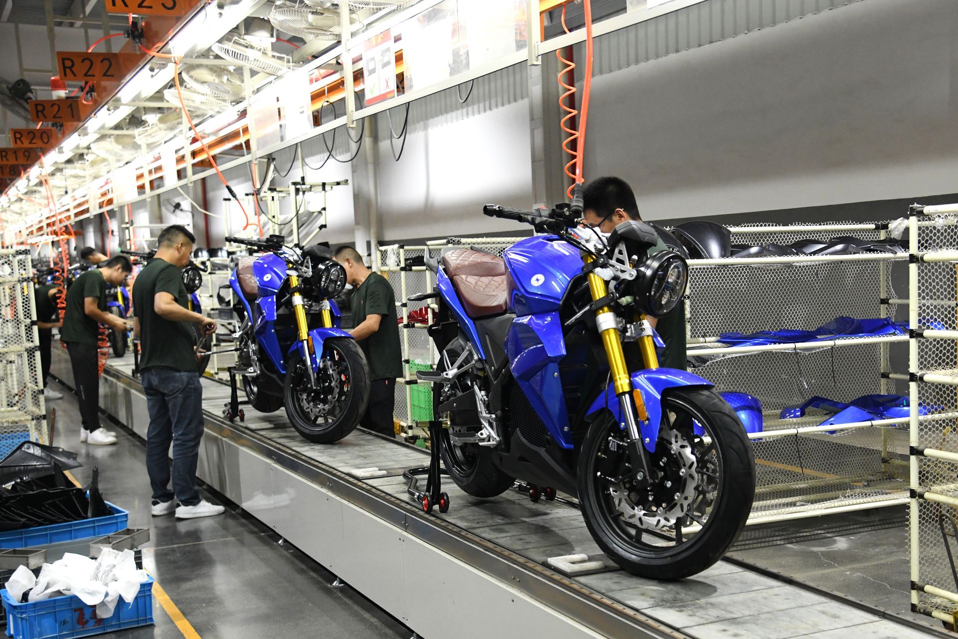 Evoke electric motorcycles are being assembled on a conveyor belt in a factory.