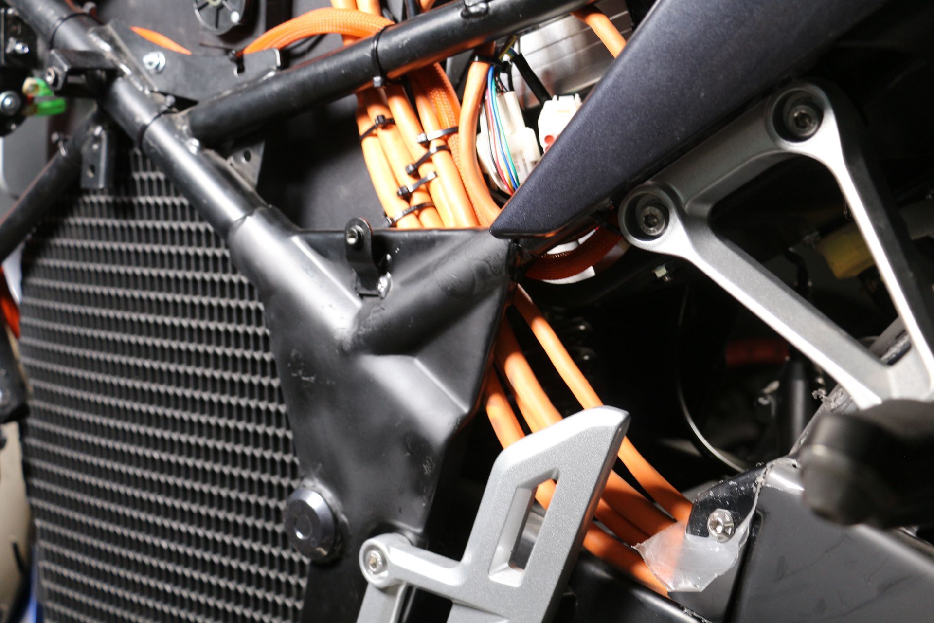A close-up of Urban series electric motorcycle engine with orange wires coming out of it