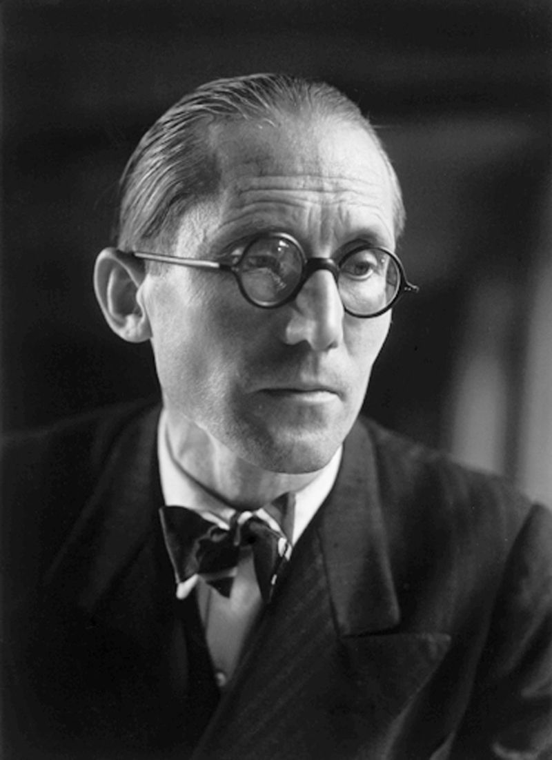 A black and white photo of a man wearing glasses and a bow tie.