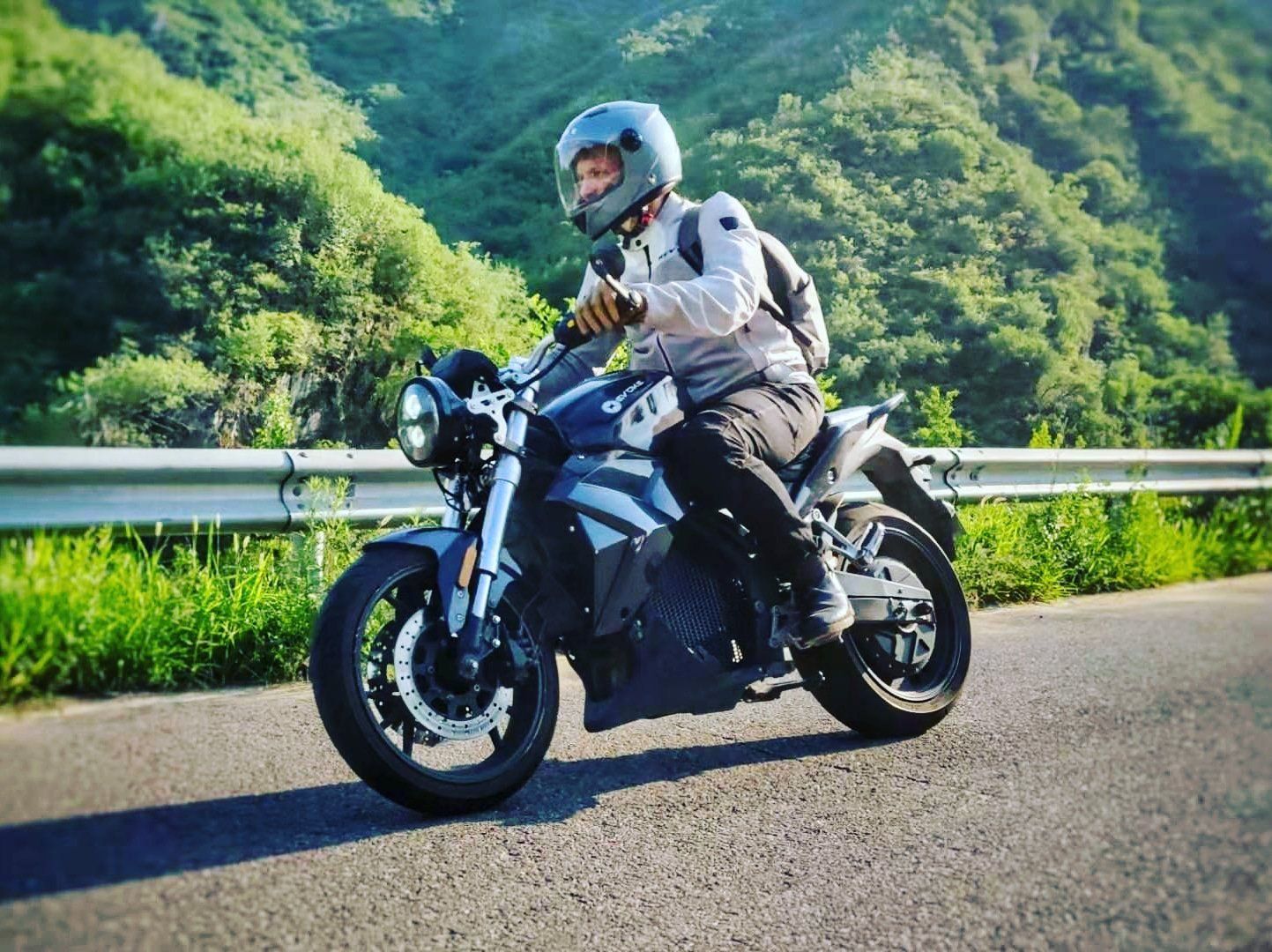 A Sebastian Chrobok wearing a helmet is riding an electric motorcycle down a road. Turkey 2023 Urban Classic