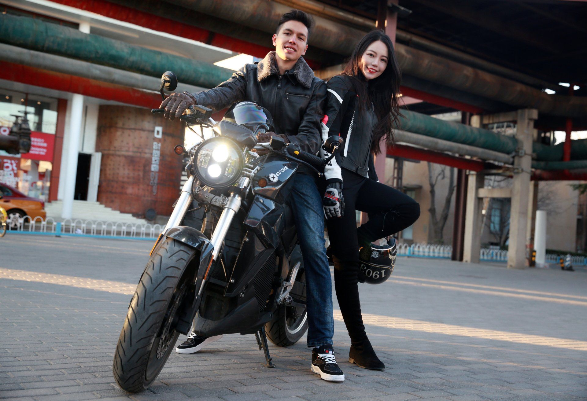 A man and a woman are sitting on an Urban Classic electric motorcycle in Paris, France 2024.