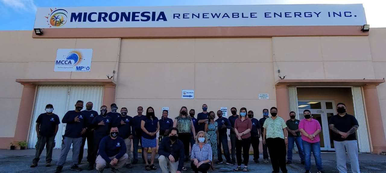 A group of people are posing for a picture in front of a building.