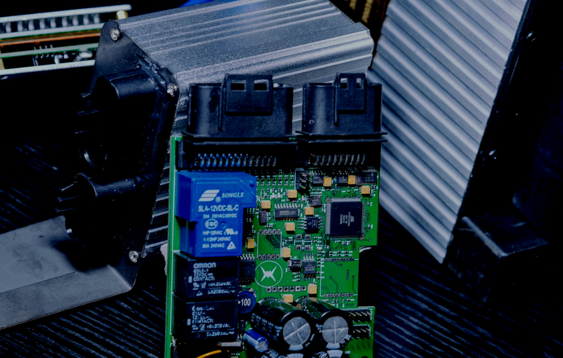 A green electronic PCB board with a blue relay on it used in Evoke Motorcycles