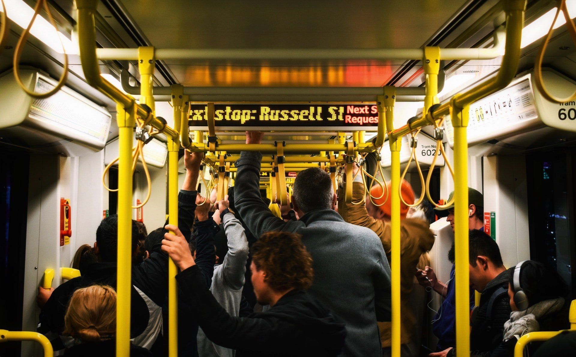 A crowded train with a sign that says 