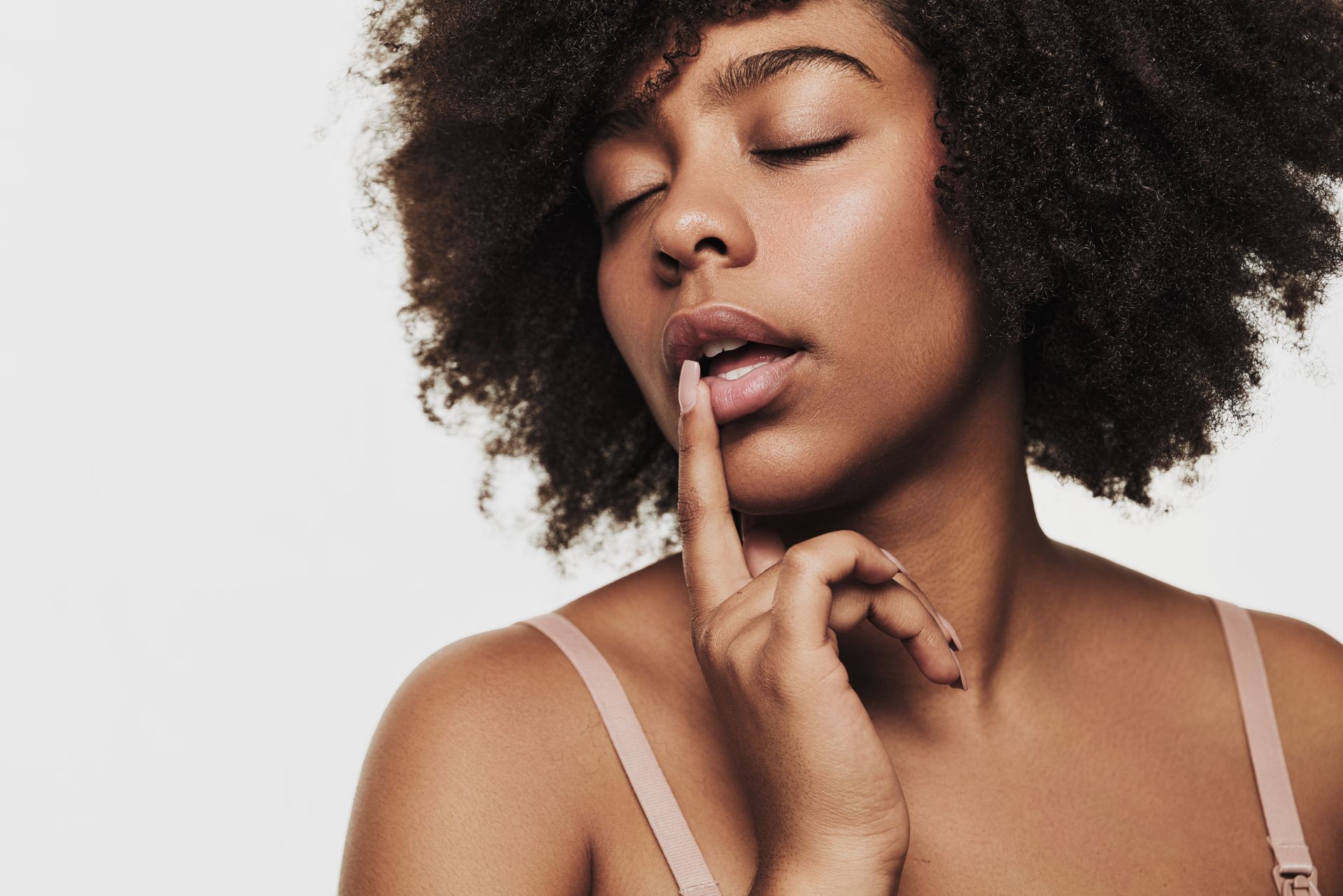 a woman with her eyes closed touches her lips with her hand