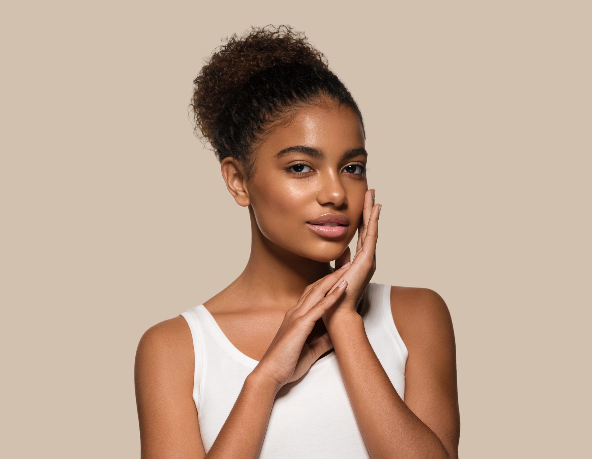 a smiling woman touches her face