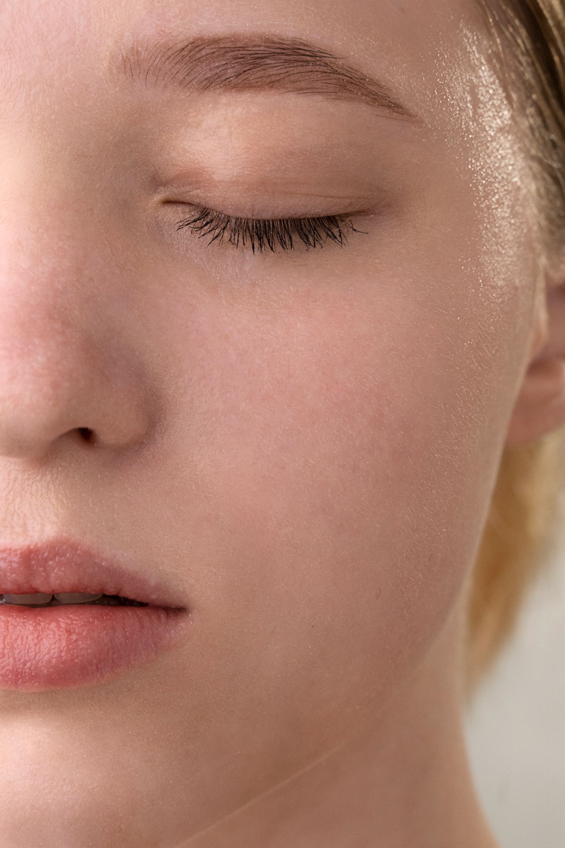 a close up of a woman 's face with her eyes closed