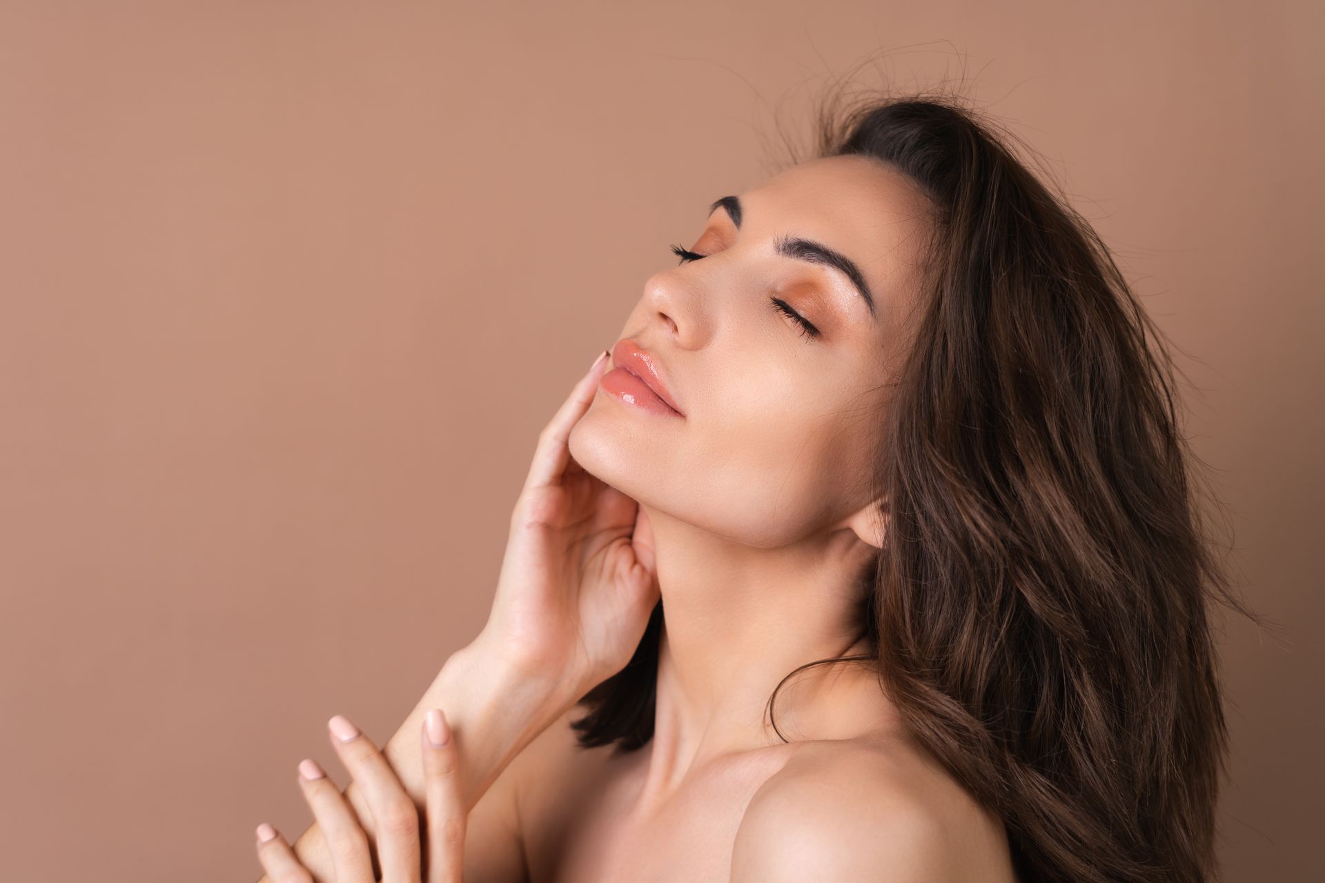 a woman with her eyes closed touches her face with her hand