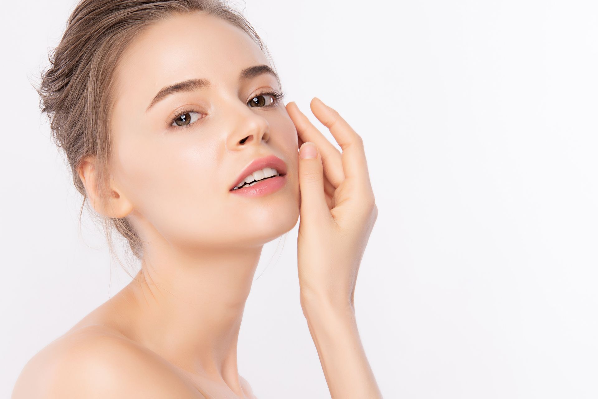 a woman touching her face with her hand and smiling