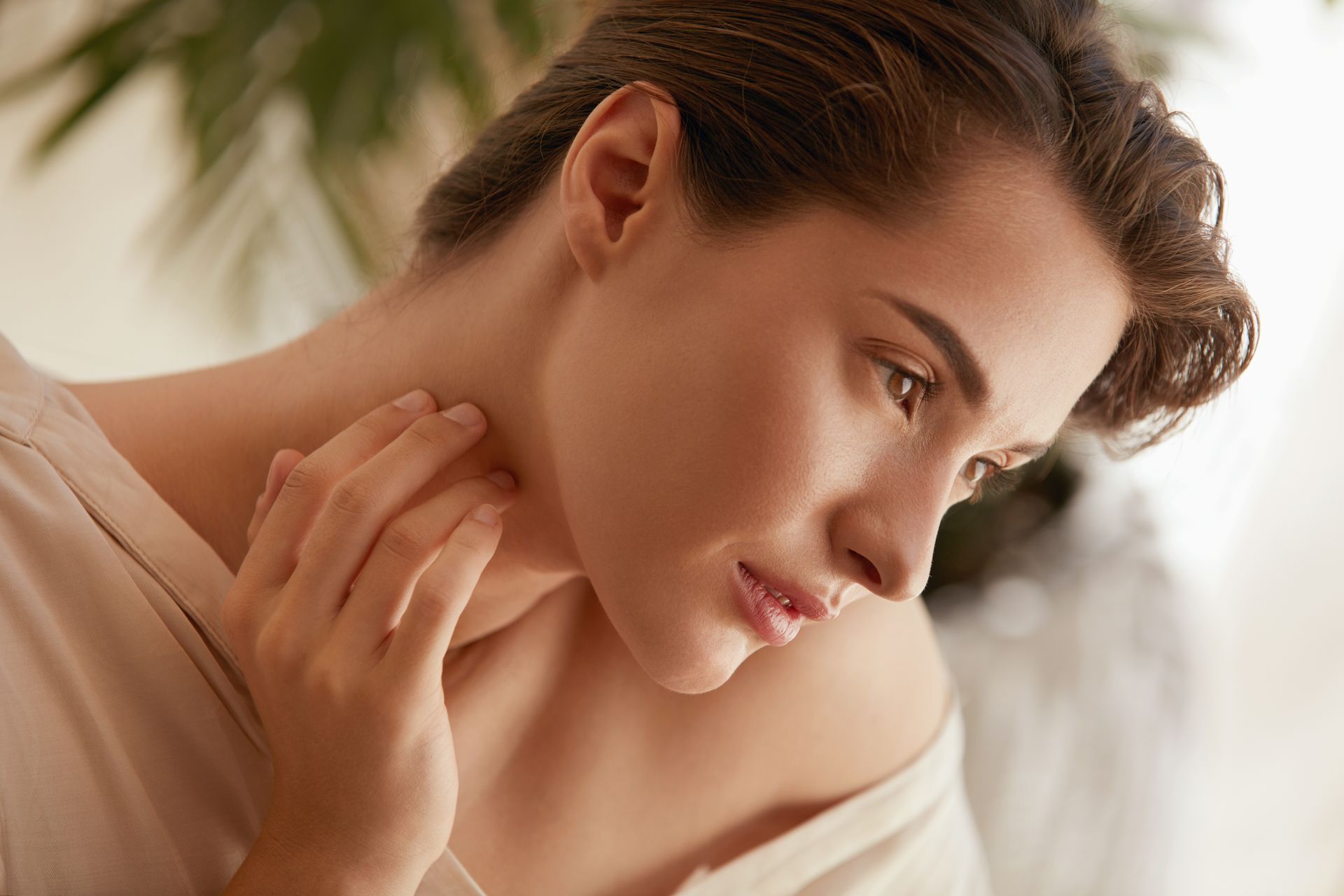 a close up of a woman 's face with her hand on her neck