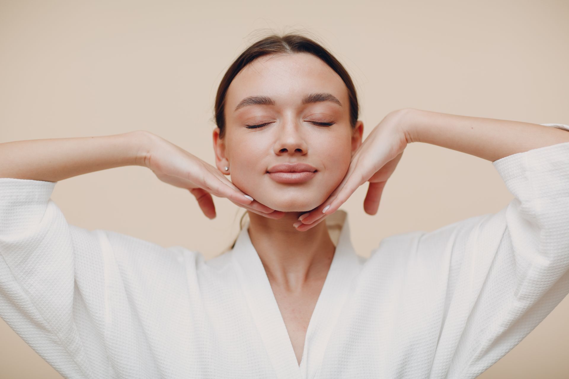 a woman with her eyes closed and her hands on her face