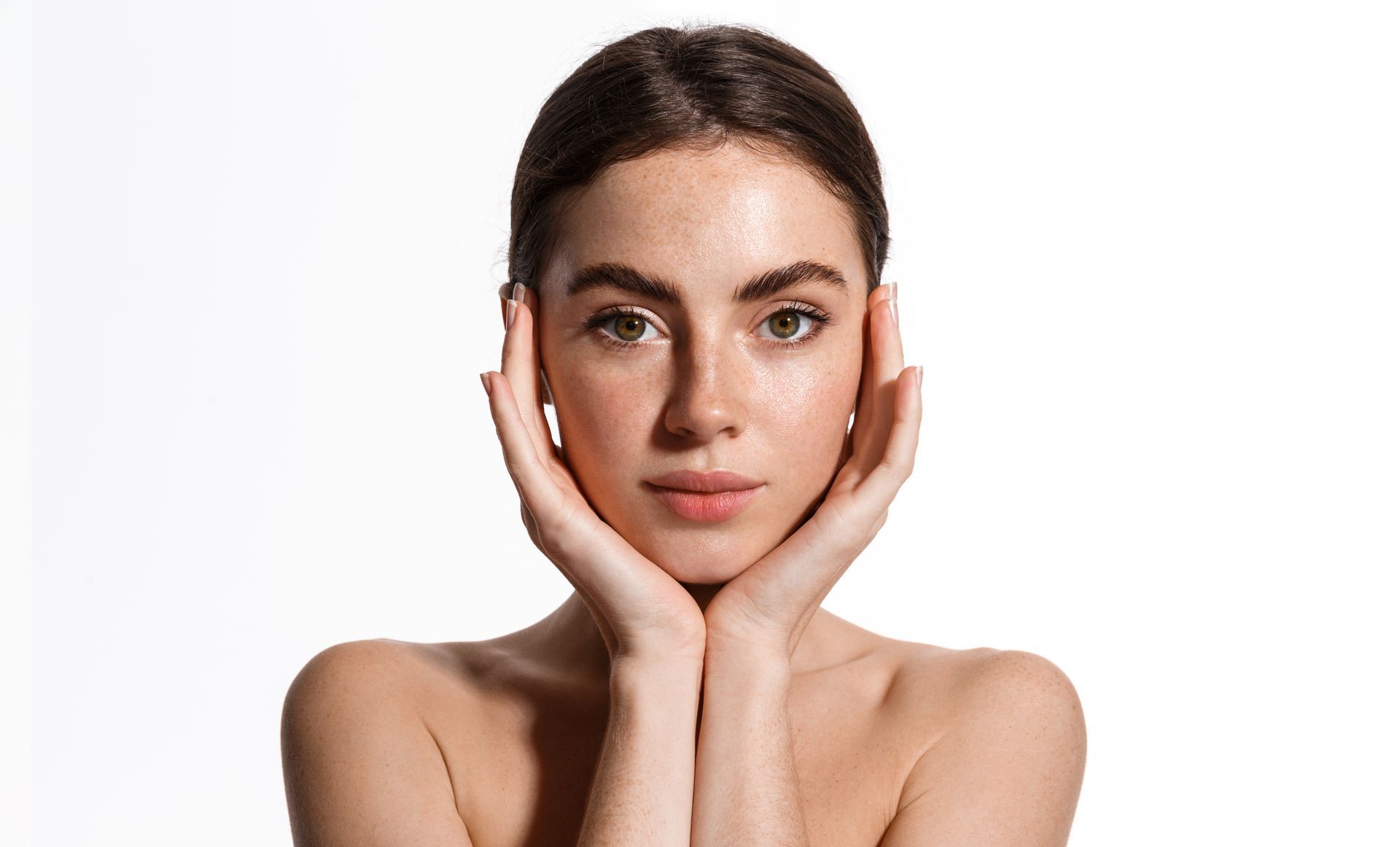 a woman with her hands on her face looks at the camera
