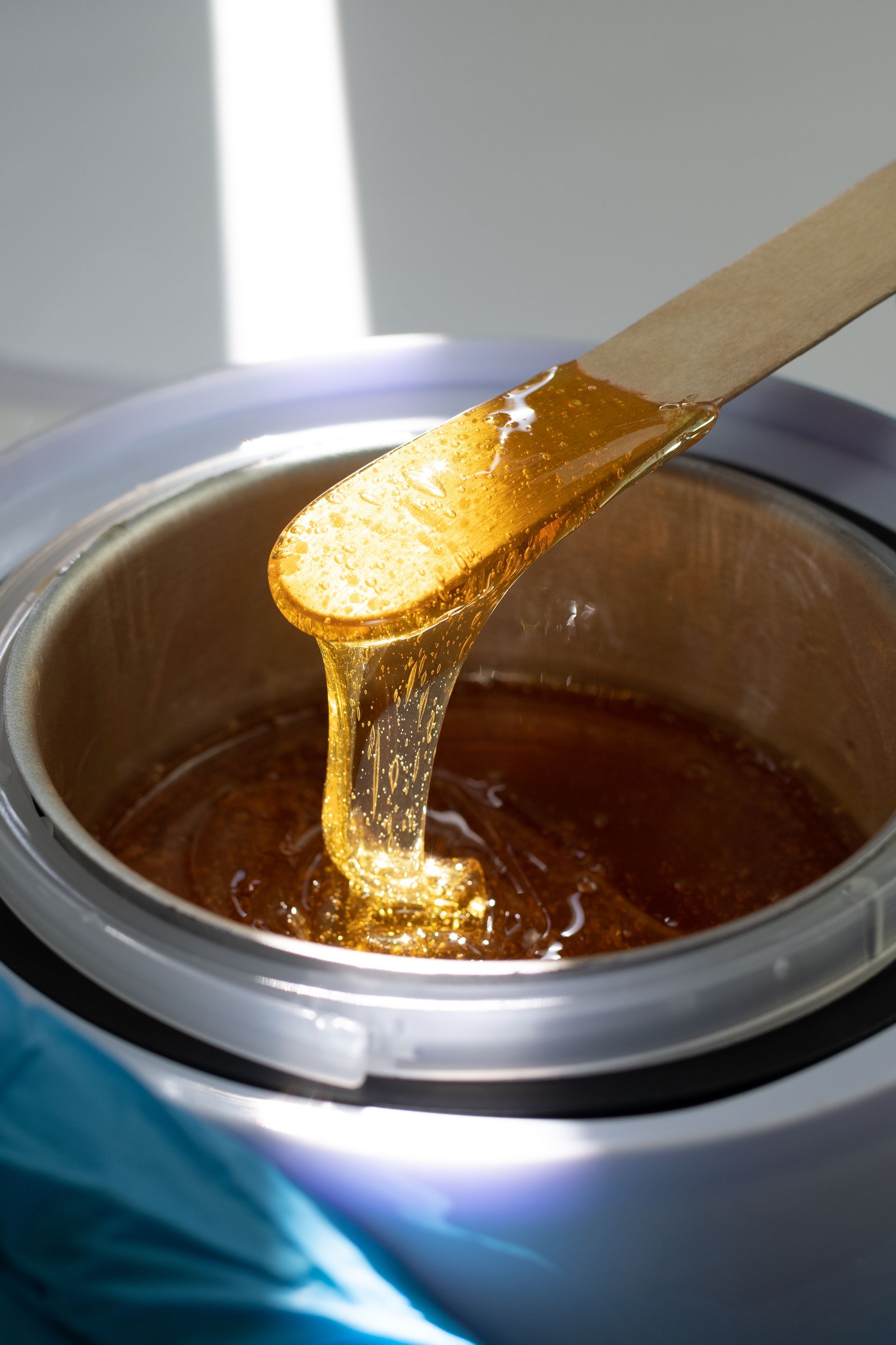 a wooden stick is sticking out of a pot of wax