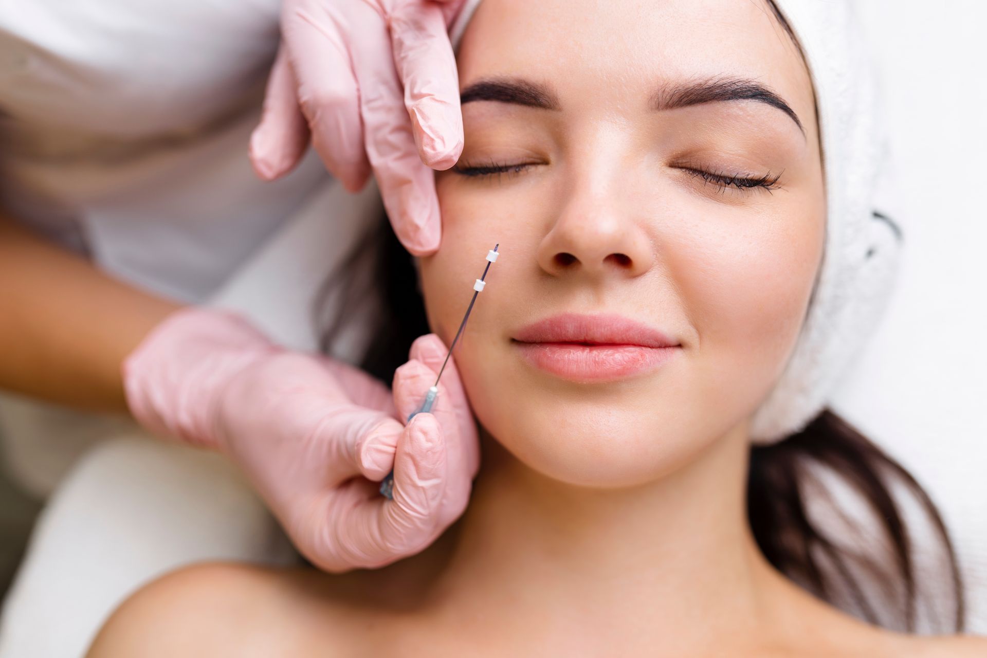 a woman is getting a needle in her face