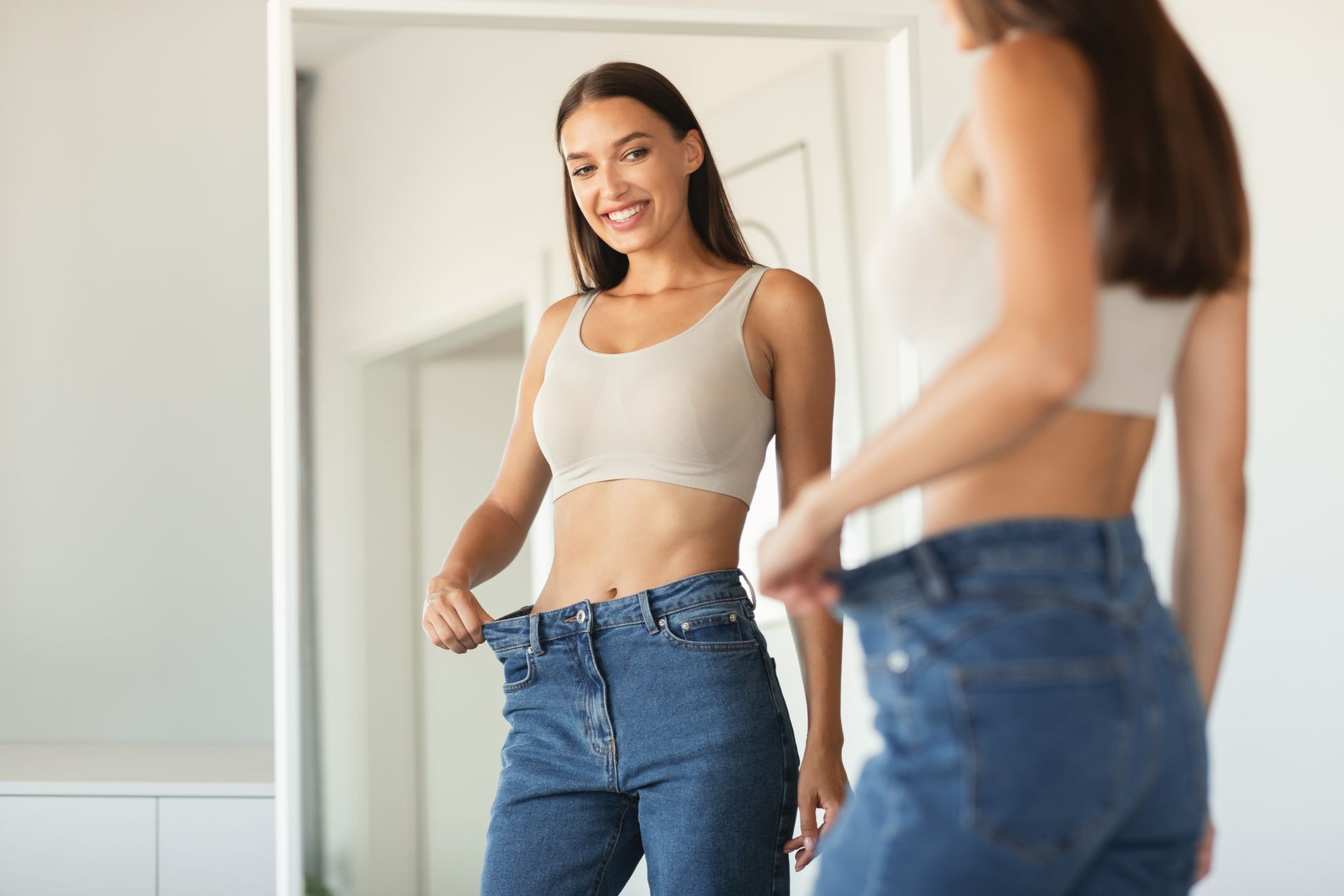 a woman is looking at herself in a mirror and smiling