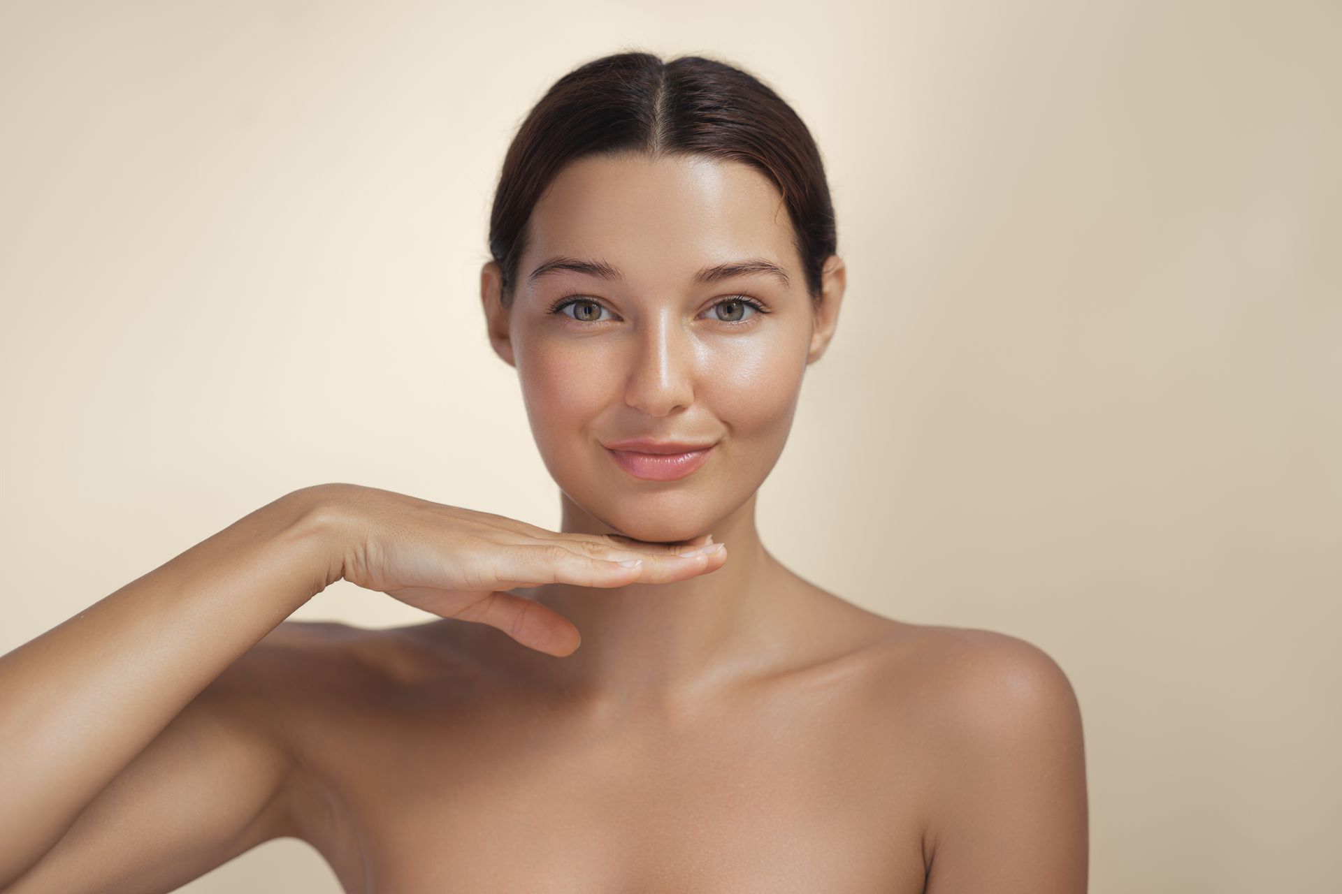 a woman without a shirt holds her hand to her chin