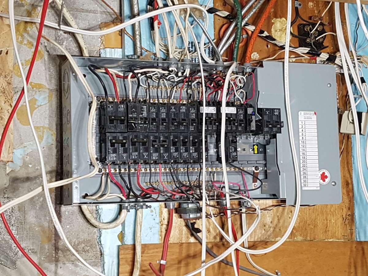 Personne tenant un panneau solaire à l'extérieur, portant des gants jaunes.