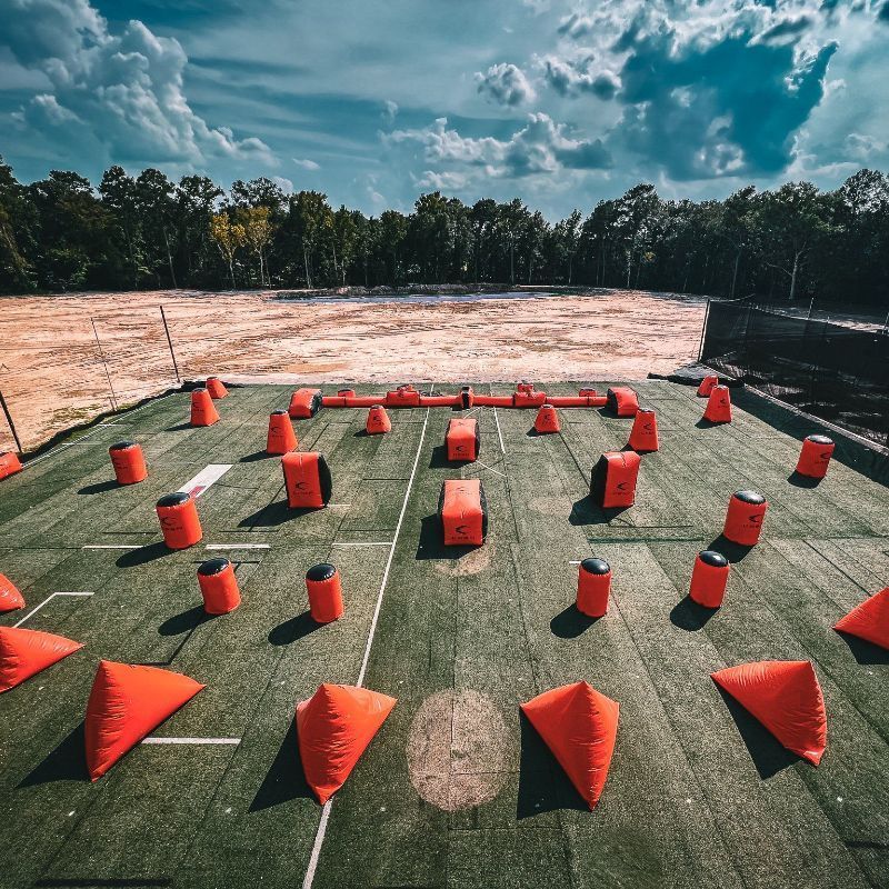 A paintball field with a lot of orange bags on it.