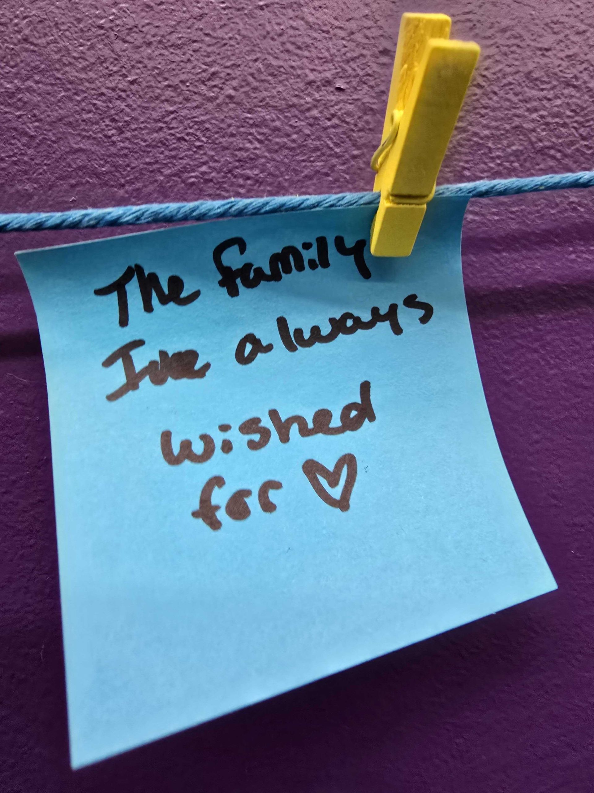 Blue sticky note clipped to a string; text reads 