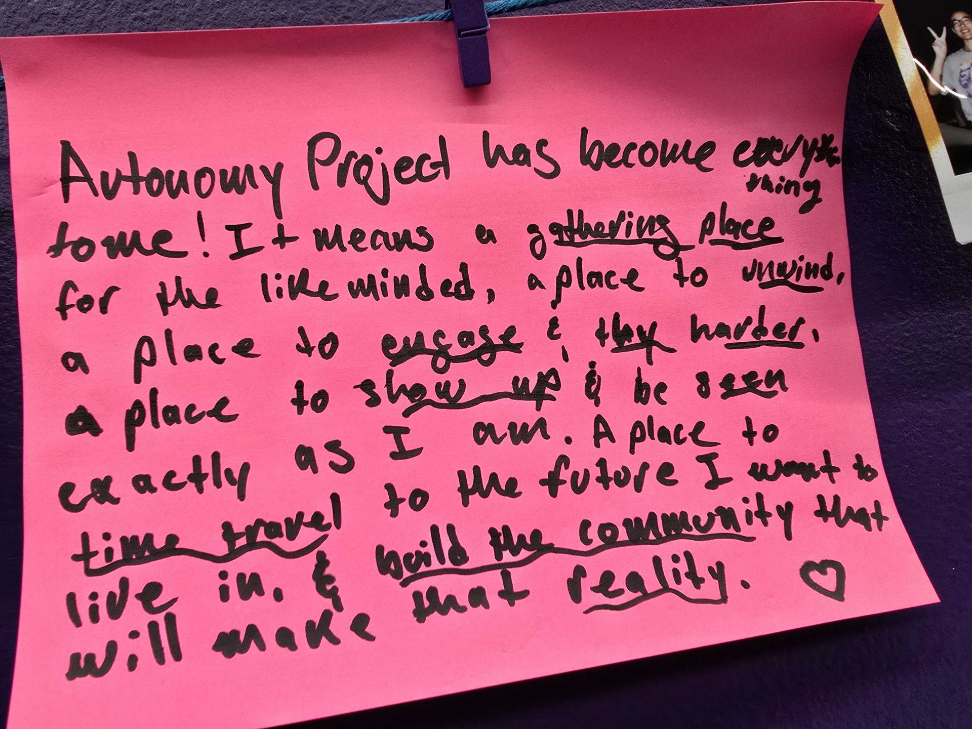 Pink sticky note with handwritten text about the Autonomy Project; emphasizes community, engagement, and future aspirations.