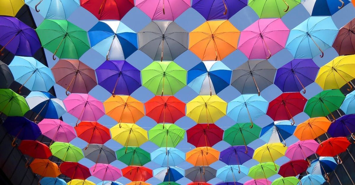 Colorful umbrellas suspended overhead against a blue sky.