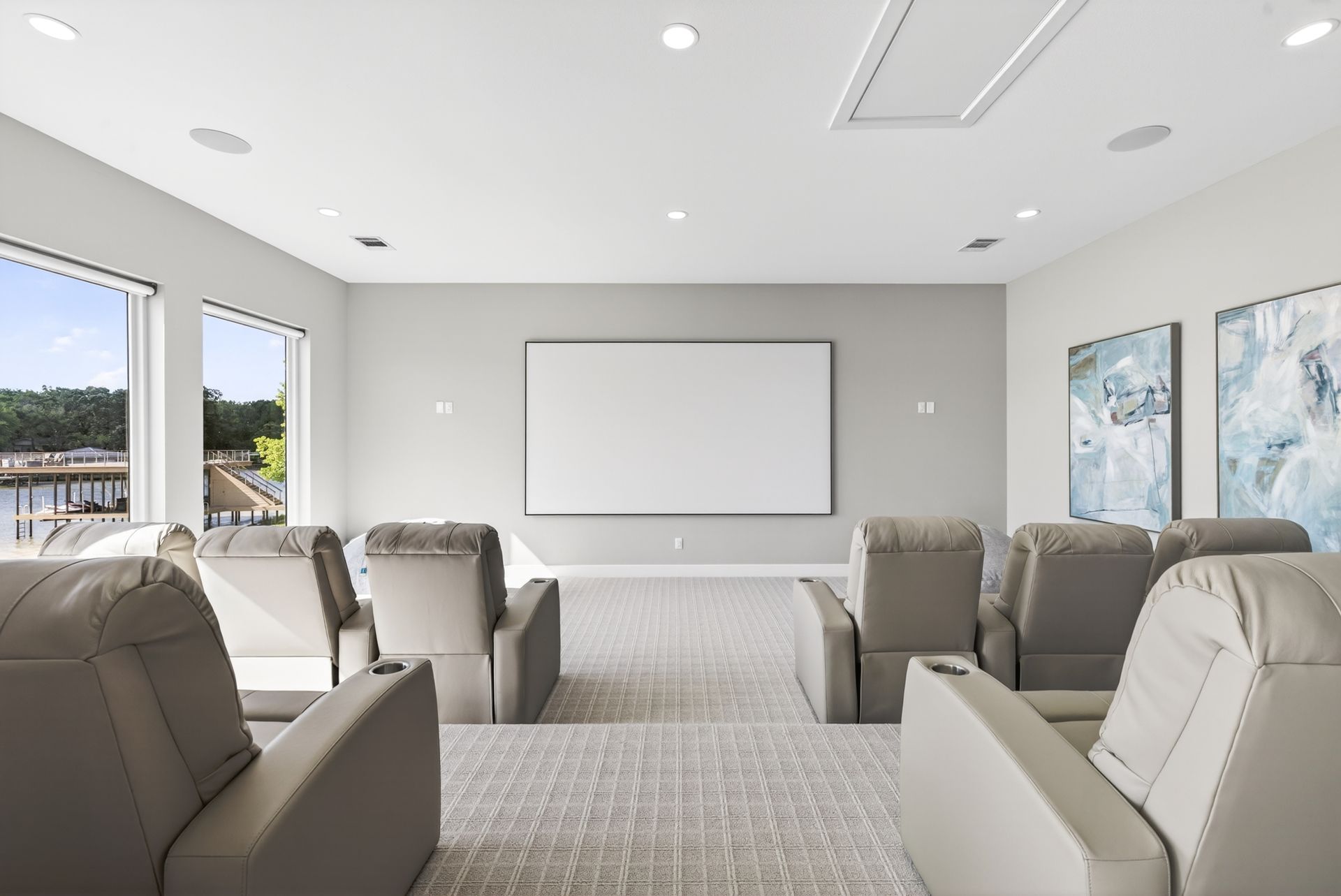 Modern meeting room with beige chairs, a whiteboard, and large windows overlooking a campus.