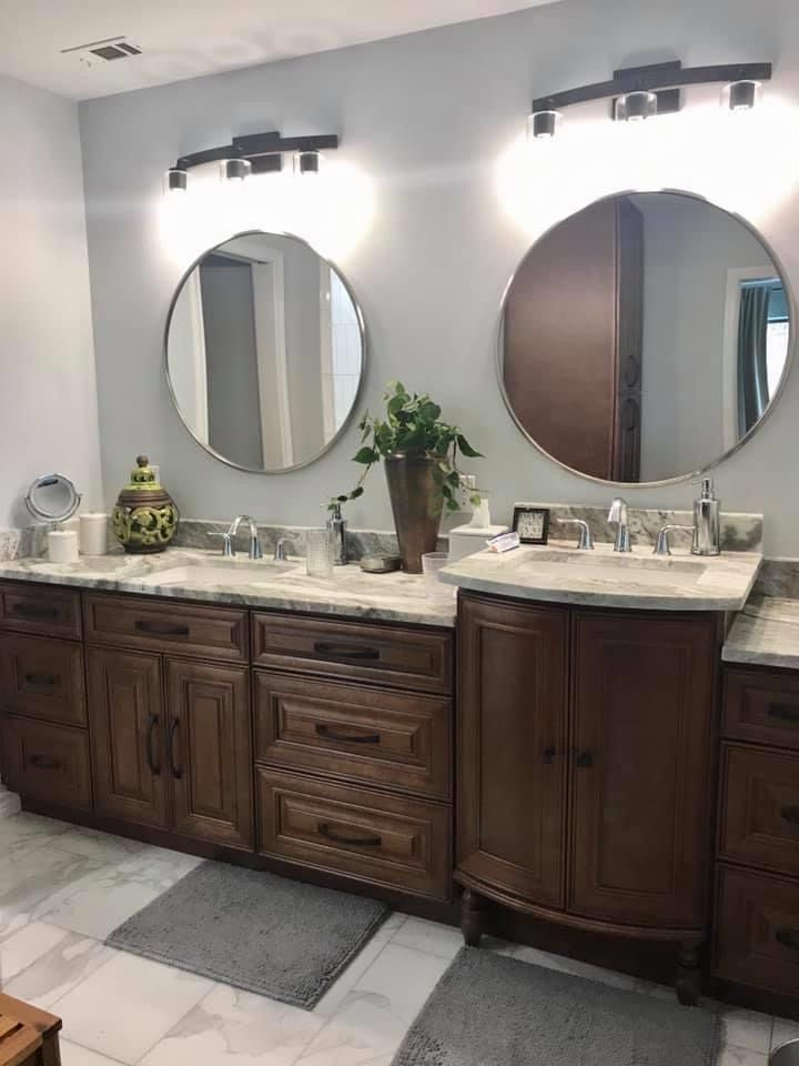 A bathroom with two sinks and two round mirrors.