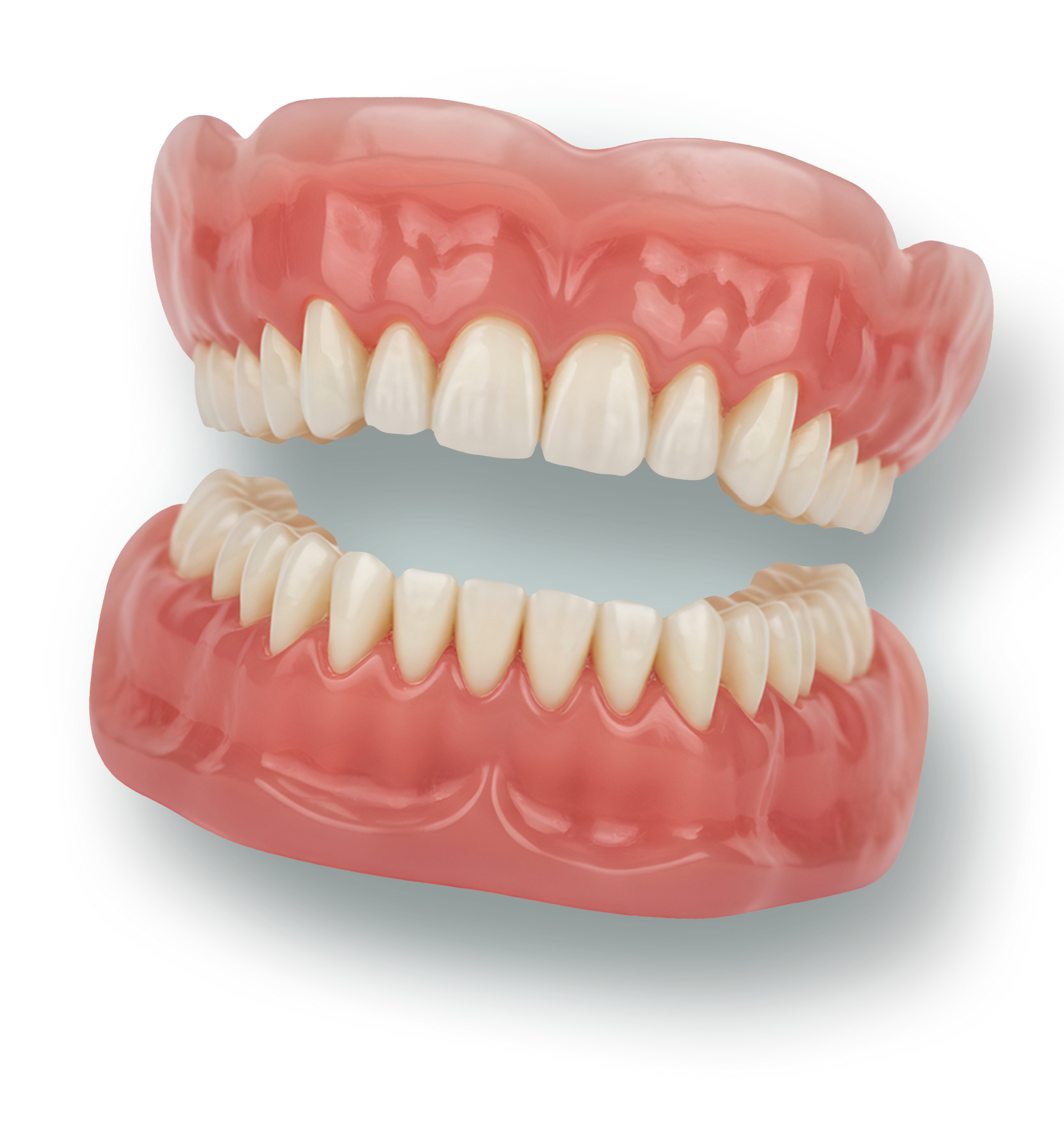 Upper and lower pink dentures with white teeth, shown separated on a plain background