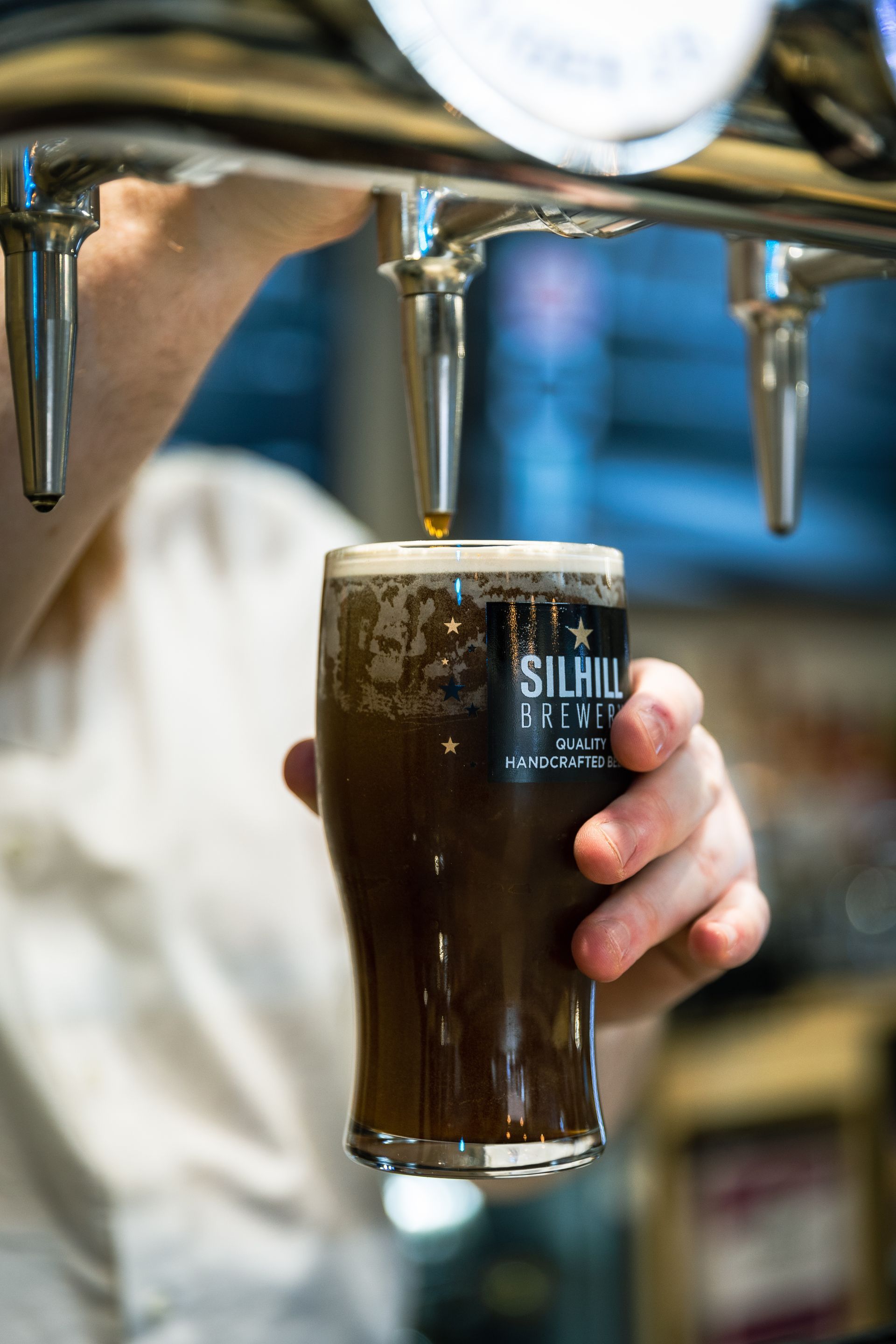 A person is pouring beer into a glass that says silvia brewery
