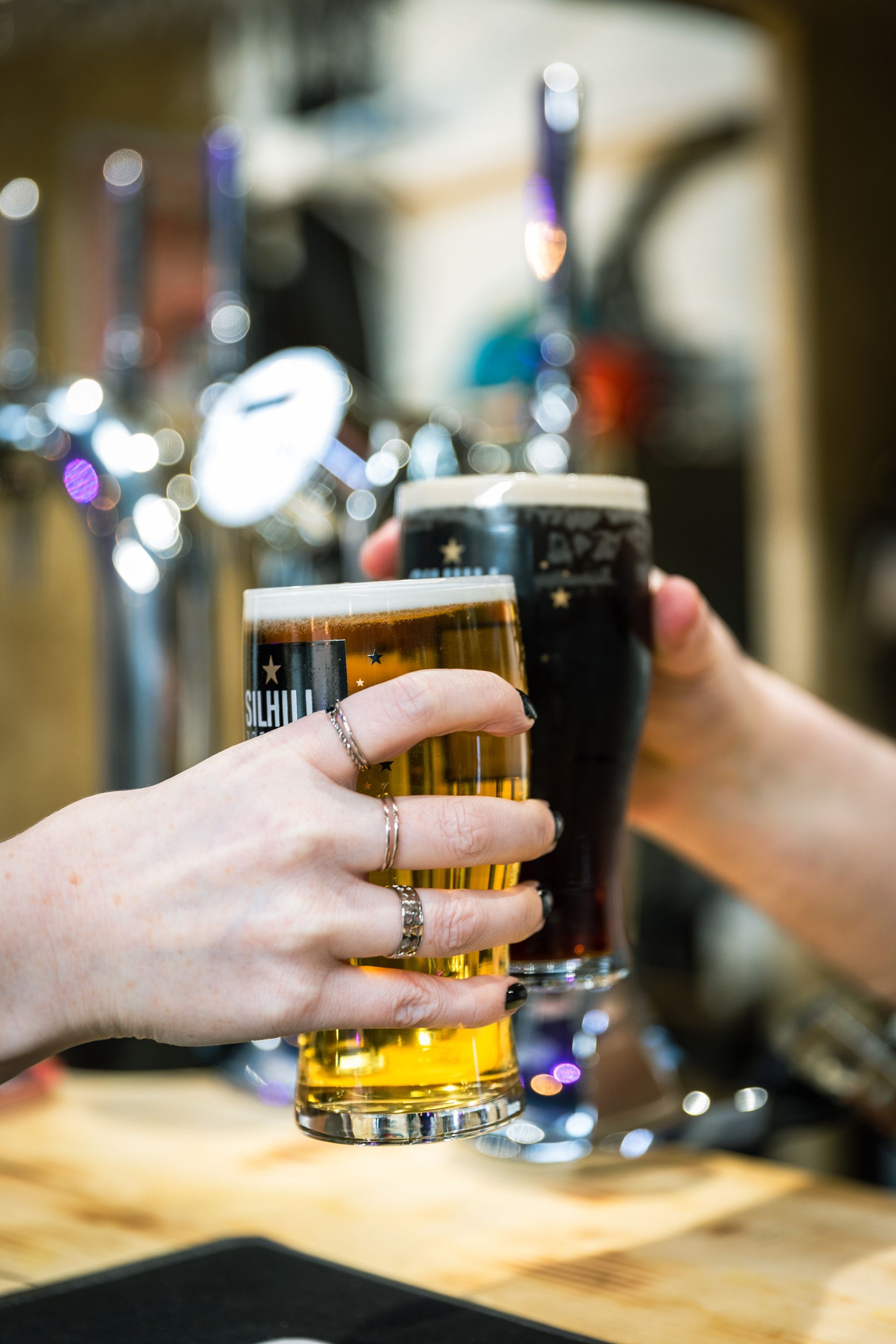 Two people are toasting with two glasses of beer.