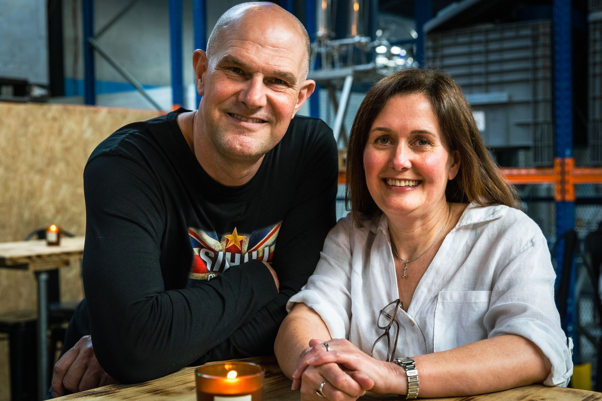 A man and a woman are sitting at a table with a candle.