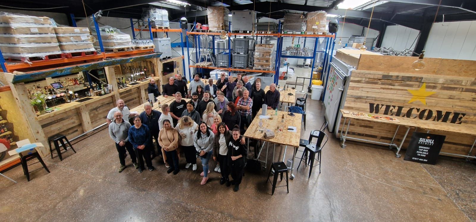 A group of people are posing for a picture in a warehouse.