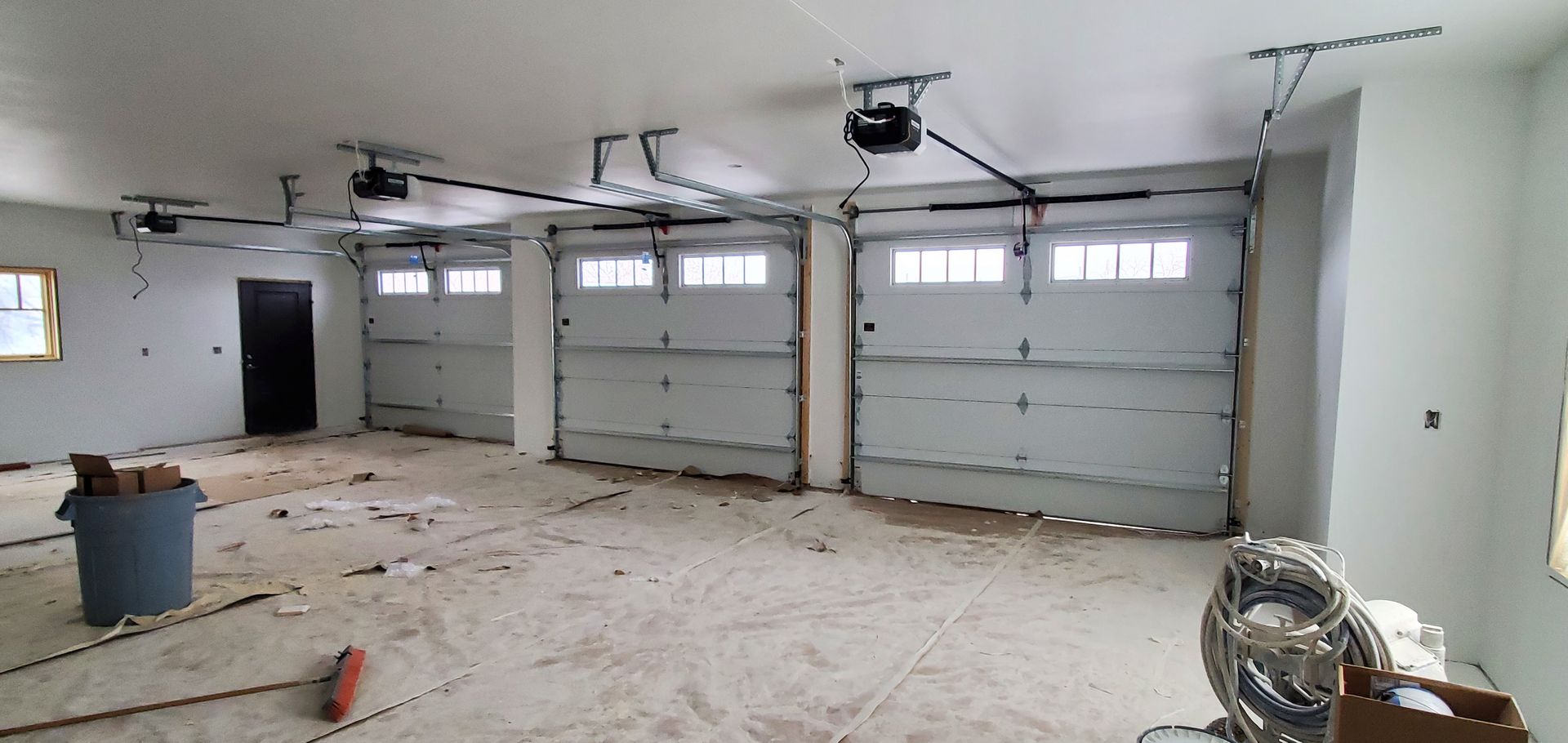 A garage with a lot of garage doors and a fan hanging from the ceiling.