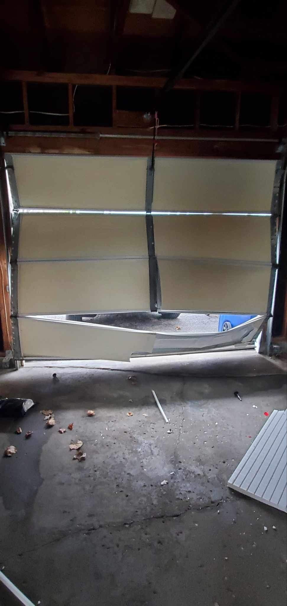 A garage door with a broken section of it is open.