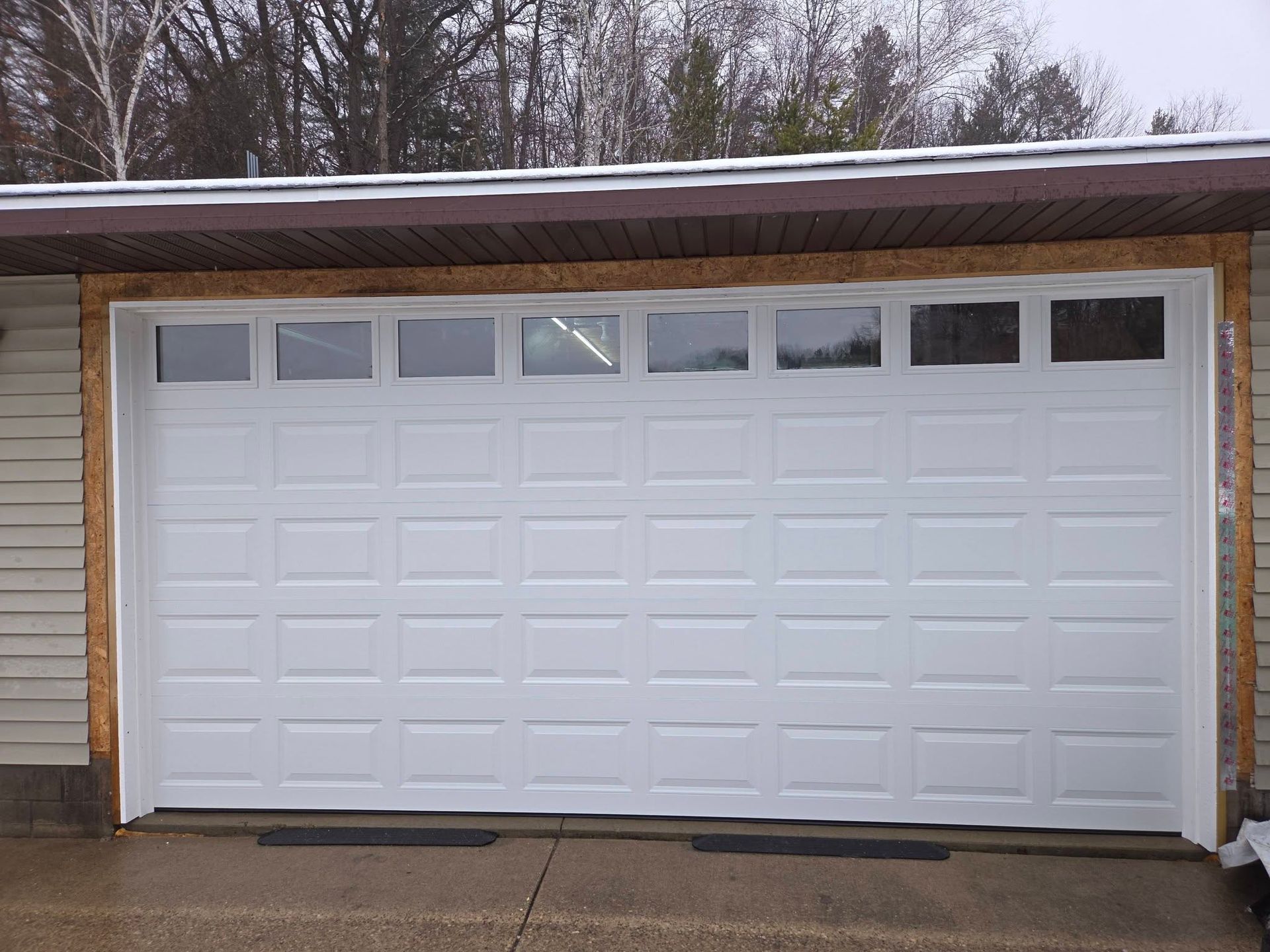 White garage door with small windows on a house exterior in winter
