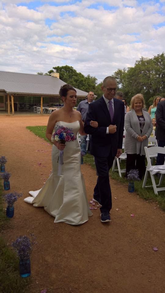 Bride and groom walking arm-in-arm at an outdoor wedding reception under a canopy